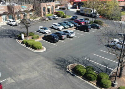 drone view of paved parking lot in shopping center