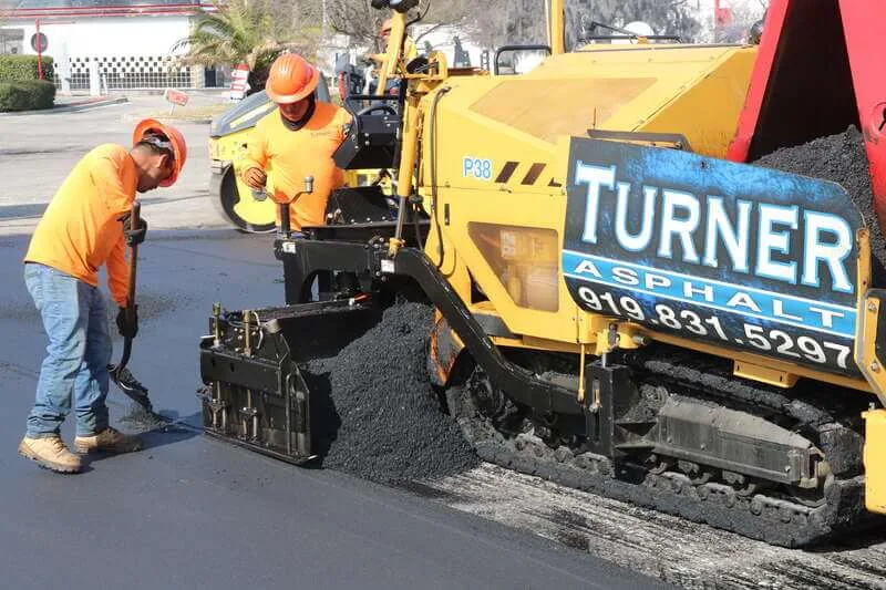 Turner Asphalt crew operating a paving machine during a commercial asphalt installation