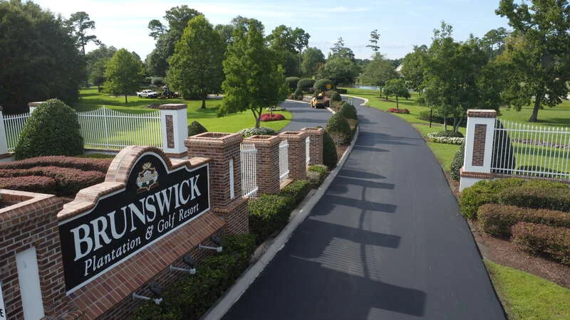 entrance sign of golf course with freshly paved road
