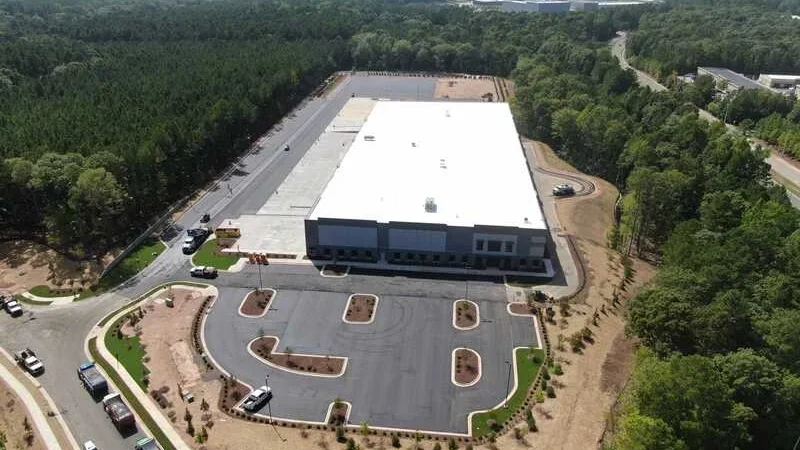 aerial view of in progress big box store parking lot being paved