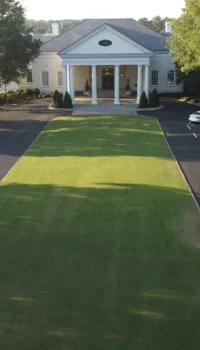 aerial view of a country club lawn with a freshly paved road
