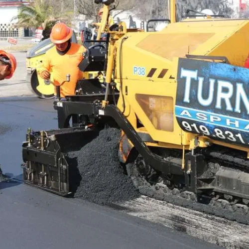 Turner Asphalt crew operating a paving machine during a commercial asphalt installation